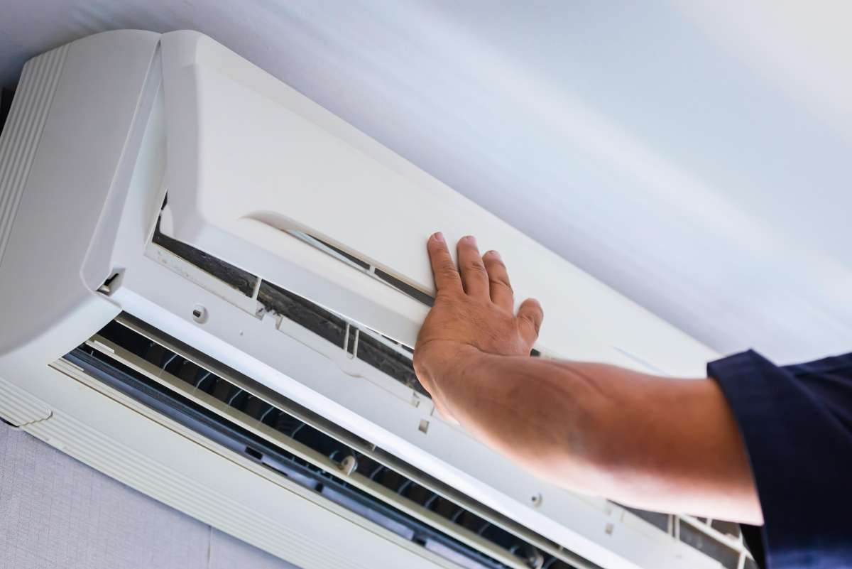 a person repairing an air conditioning unit